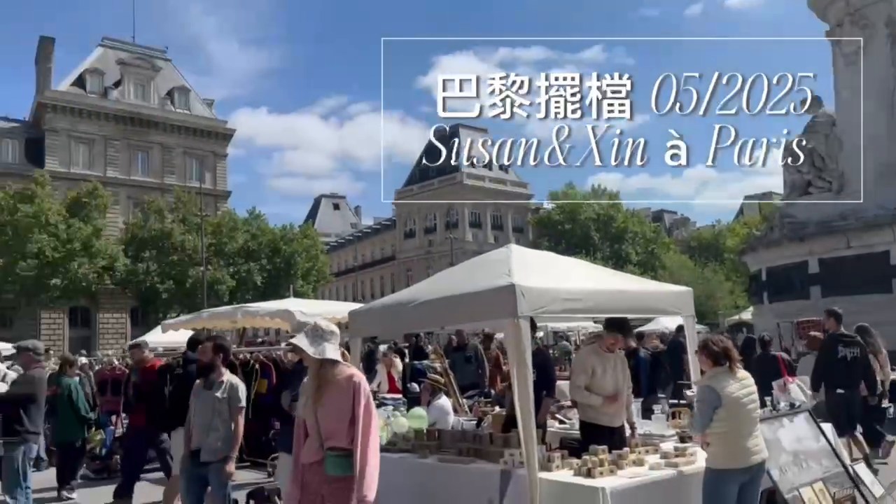 White market canopies and visitors beneath a blue sky in Paris; the video title reads May 2025.